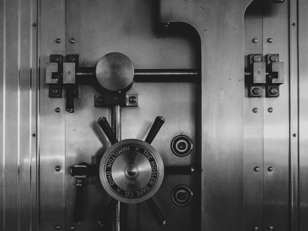 Close-up of a steel vault door locking mechanism, representing controlled access and compliance-ready security evidence.